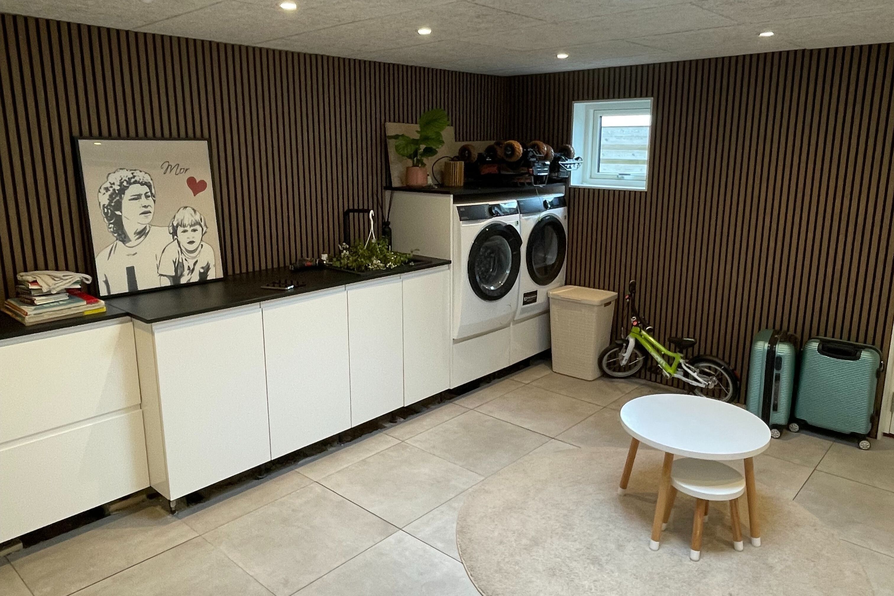 Specialbygget vaskerum med hvide elementer og akustikpaneler i træ.