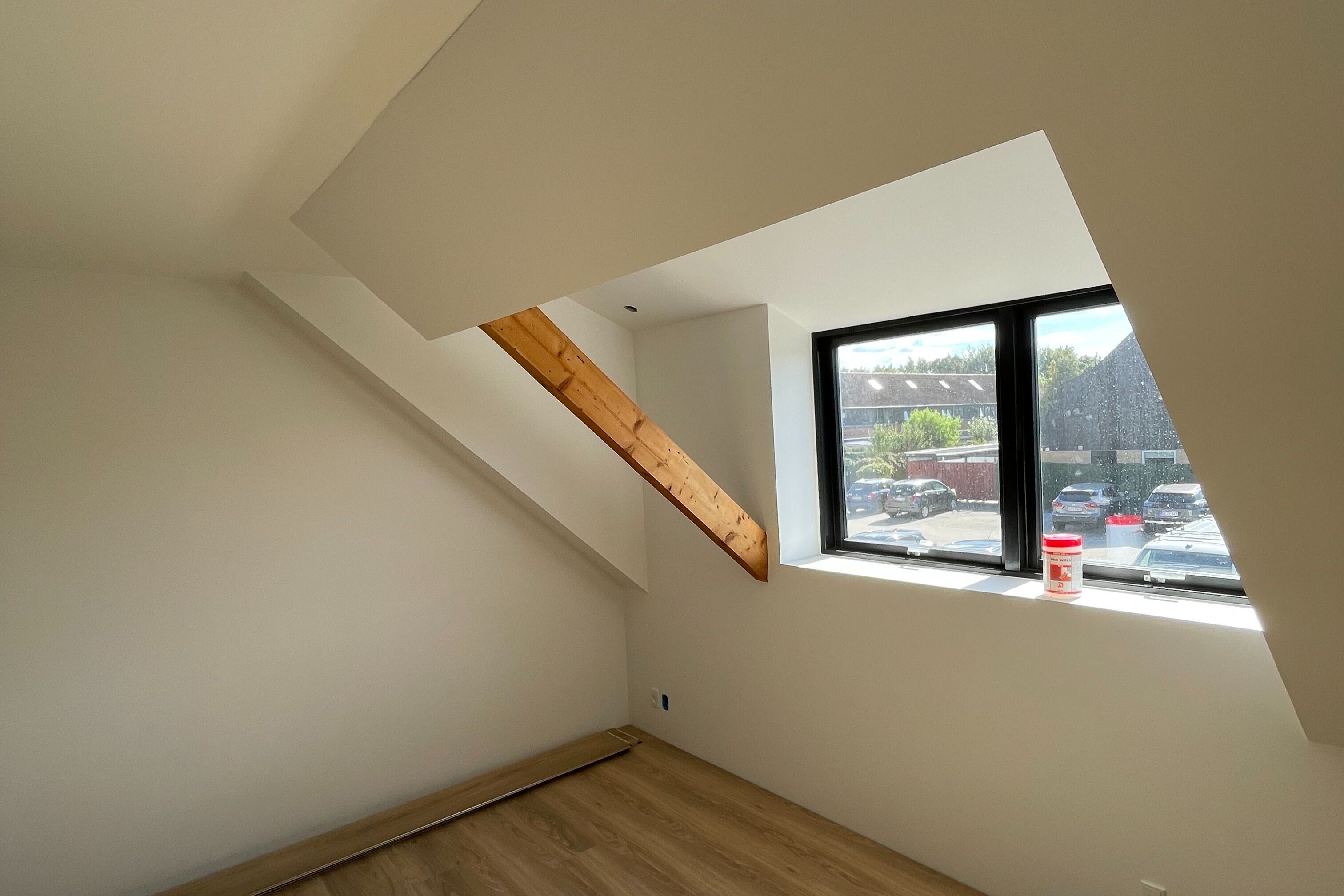 Montering af moderne sort rammevindue i lys tagetage udført af Tømrerfirmaet Basker.